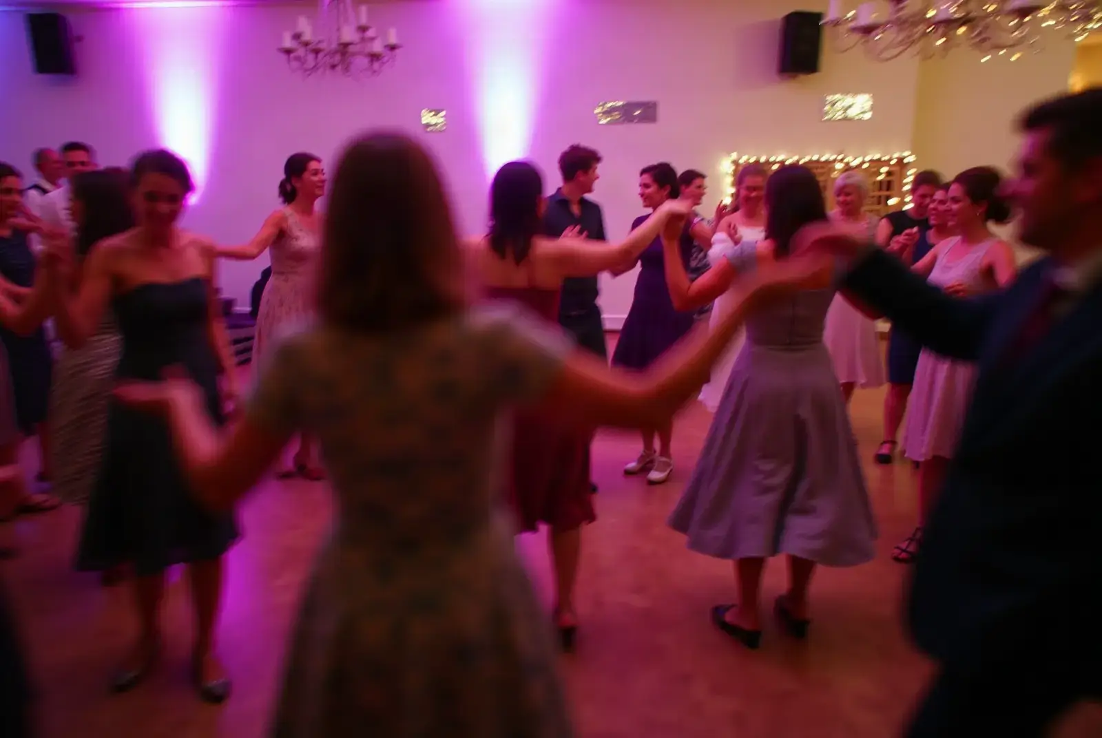 Party guests dancing a ceilidh in purple light