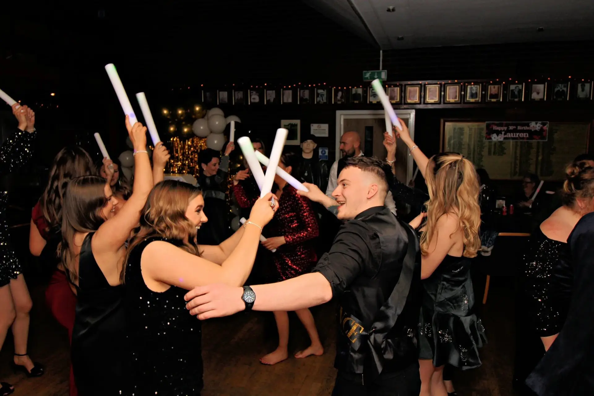 Birthday party guests dancing with their glow sticks raised
